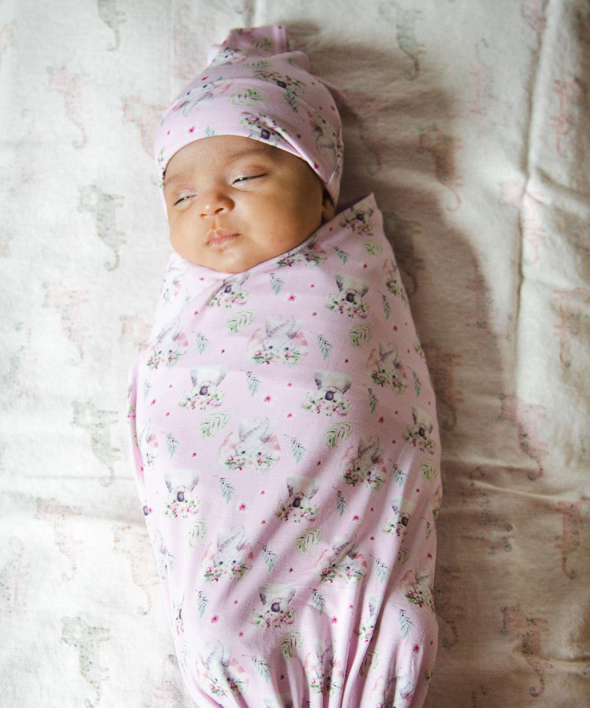 Baby in a pink pattern swaddle sleeping